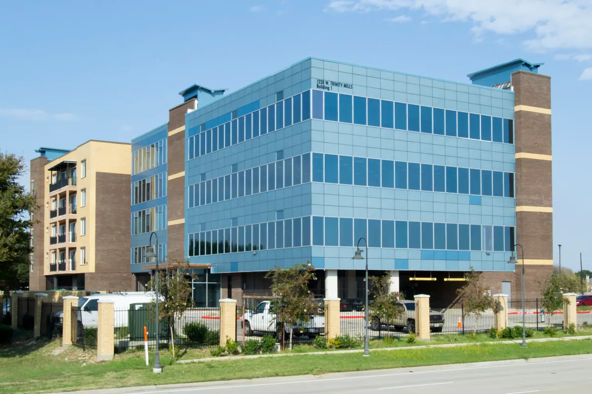 A modern glass office building on West Trinity Mills Road in Carrollton, Texas