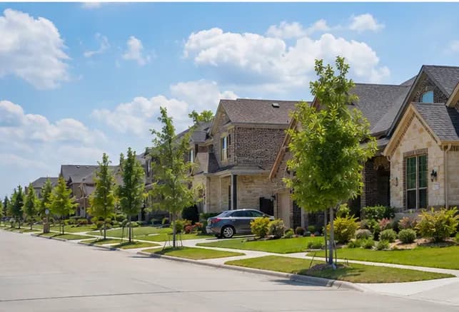 A street of newer two-story brick and stone homes in a North Texas neighborhood
