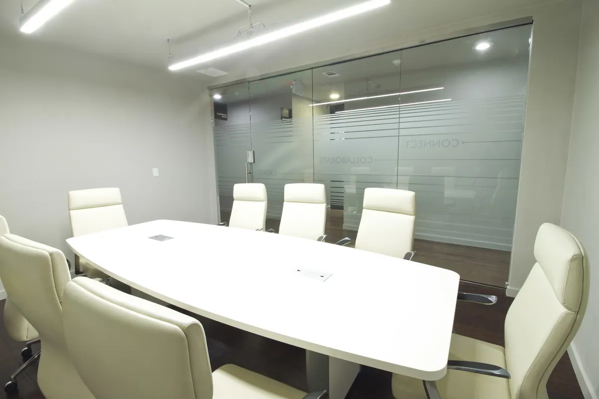 A conference room with a white table and cream chairs inside 3712 Old Denton Rd, Carrollton